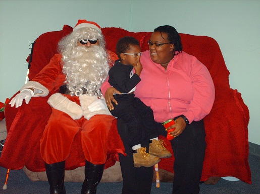 Santa posing with a Mother and child